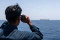 Американский моряк на борту эсминца USS Rafael Peralta (DDG 115) наблюдает за коммерческим судном, патрулирующим Аравийское море и обеспечивающим соблюдение американской блокады Ирана. Фото: Центральное командование США
