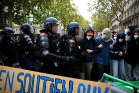Французская полиция по борьбе с беспорядками противостоит протестующим, образовавшим живую цепь за баррикадой, чтобы перекрыть бульвар Сен-Жермен, во время столкновений в ходе акции протеста у университета Sciences Po в Париже, Франция, 7 октября 2026 год