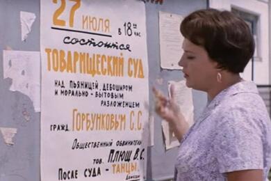 Героиня Нонны Мордюковой клеит объявление о предстоящем товарищеском суде над героем Юрия Никулина. Кадр из фильма «Бриллиантовая рука» 1968 года