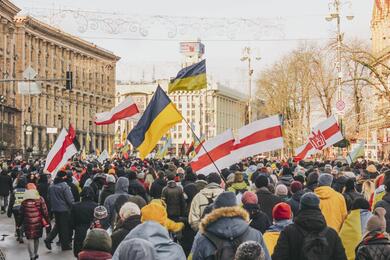 Белорусы с бело-красно-белыми и украинскими флагами на акции “Марш єдності” в Киеве 12 февраля 2022 года. Фото: facebook.com/aleh.auchynnikau
