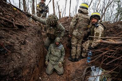 Украинские солдаты с пленным военнослужащим российской армии, на позициях недавно отвоеванных в ходе контрнаступления, недалеко от прифронтового города Бахмут в Донецкой области, Украина 11 мая 2023 года. Фото: Reuters