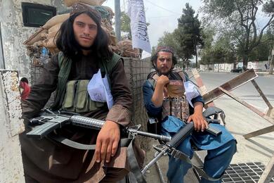 Members of Taliban forces sit at a checkpost in Kabul