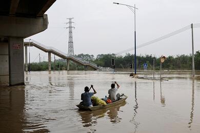 Эвакцация жителей, из затопленной после сильных дождей, деревни Жители гребут на лодке по наводнению после сильного дождя в деревне Сяшахэ, в приговоде Цинъюань, провинция Гуандун, Китай 22 апреля 2024 года. Фото: Reuters