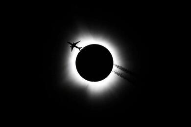 Самолет пролетает во время полного солнечного затмения в Блумингтоне, Индиана, США, 8 апреля 2024 года. Фото: Reuters