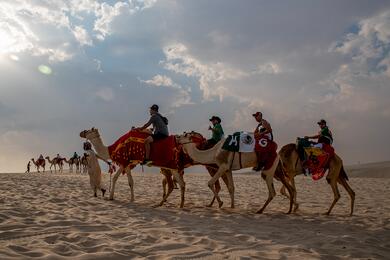 Туристы и посетители наслаждаются экскурсиями на верблюдах по пустыне в городе Месаид, Катар, 8 декабря 2022 года. Фото: Reuters