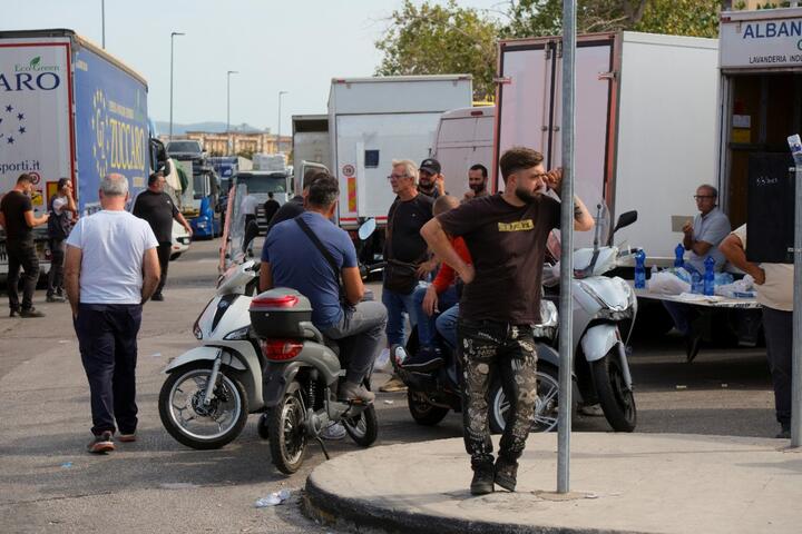Люди собираются у припаркованных грузовиков во время протеста дальнобойщиков против роста цен на топливо и транспортные расходы, нарушившего цепочки поставок по всей Сицилии и южной Италии. Палермо, Италия, 20 октября 2026 года. Фото: Reuters