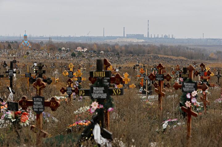 Могилы на кладбище, на заднем плане виден металлургический завод "Азовсталь", в поселке Старый Крым под Мариуполем, оккупированная Россией территория Украины, 9 ноября 2022 года. Фото: Reuters