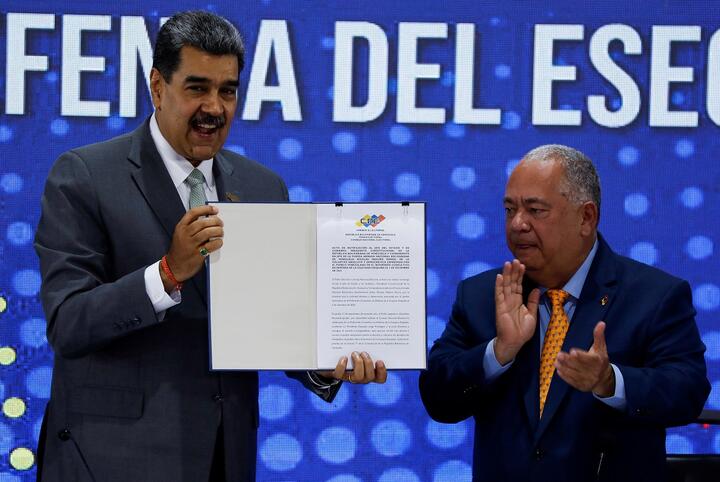 Президент Венесуэлы Николас Мадуро держит документ, переданный ему главой Национального избирательного совета Венесуэлы Элвисом Хидробо Аморосо, в котором зафиксированы итоги референдума 3 декабря в Венесуэле. Фото: Reuters