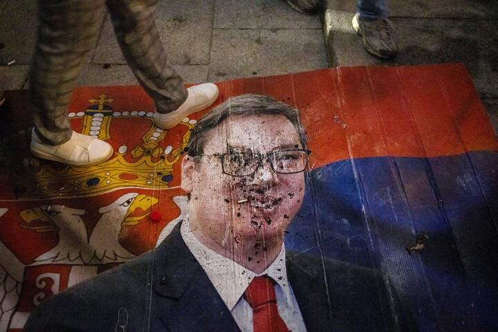 Человек наступает на плакат с изображением Александра Вучича после его поражения на выборах. Белград, Сербия, 25 октября 2026 года. Фото: Reuters
