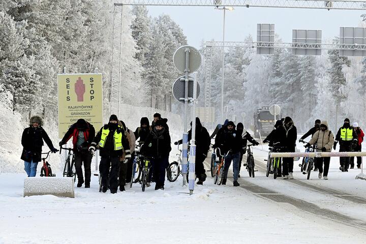 Финские пограничники и мигранты с велосипедами идут к пограничному переходу между Финляндией и Россией в Салла, Лапландия, Финляндия, 21 ноября 2023 года. Фото: Reuters